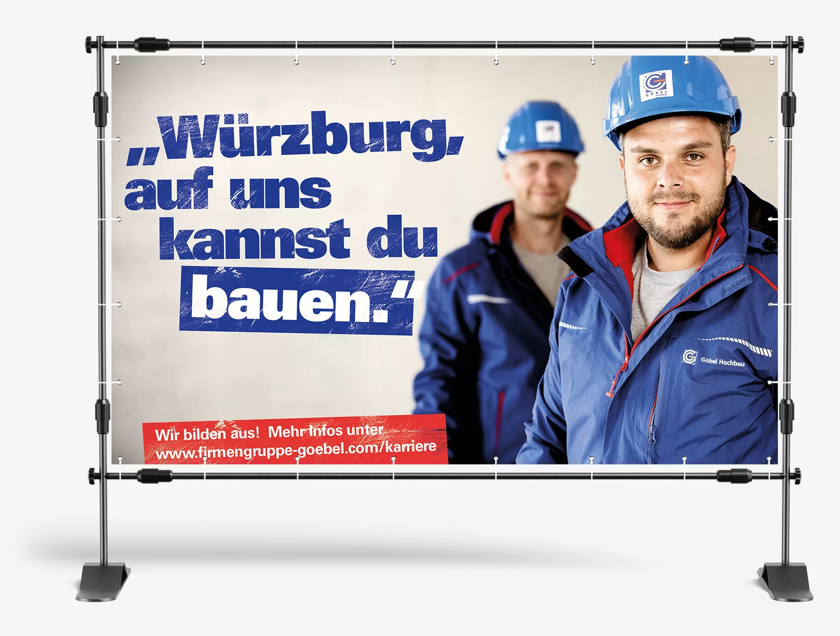 Bauzaunbanner mit zwei Firmengruppe Göbel Mitarbeiter und dem Text "Würzburg, auf uns kannst du bauen."